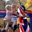 Paula Radcliffe celebrates marathon victory, holding her young daughter, wrapped in the British flag