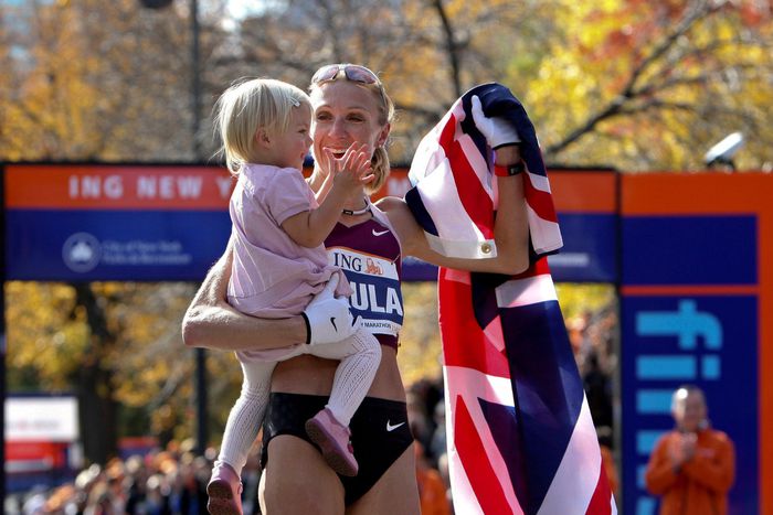 Paula Radcliffe celebrates marathon victory, holding her young daughter, wrapped in the British flag