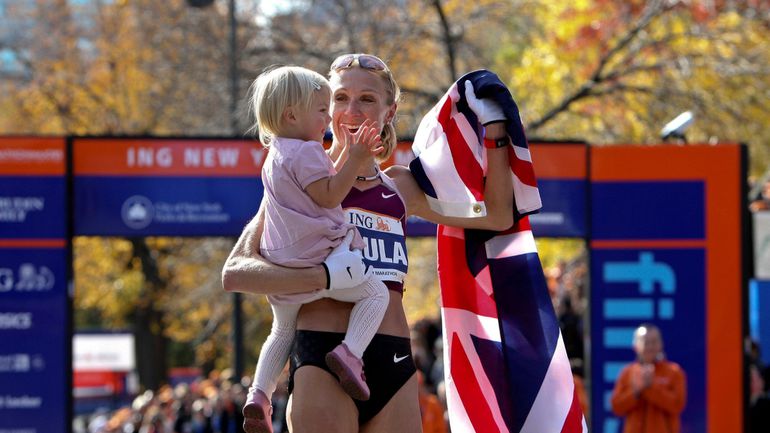 Paula Radcliffe celebrates marathon victory, holding her young daughter, wrapped in the British flag