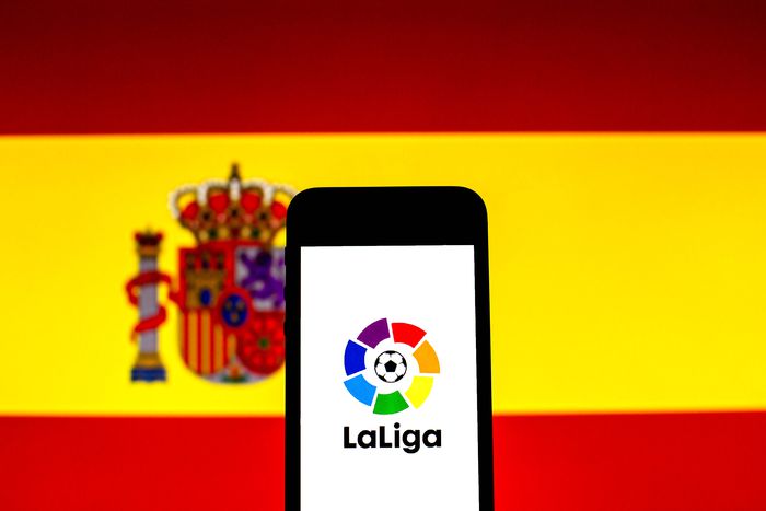 September 16, 2021, Barcelona, Catalonia, Spain: In this photo illustration a LaLiga logo seen displayed on a smartphone with a Spanish flag in the background. Barcelona Spain -