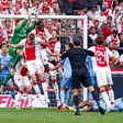 Goalkeeper Robin Roefs of NEC jumping to catch the ball, Dies Janse of AFC Ajax, Chuba Akpom of AFC Ajax, Wout Weghorst of AFC Ajax during the Dutch Eredivisie match between AFC Ajax and NEC at Johan Cruijff ArenA on May 11, 2025