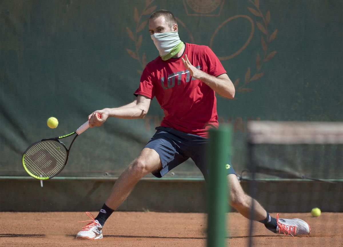 Slovenský tenisový reprezentant Norbert Gombos s rúškom na tvári počas tréningu.