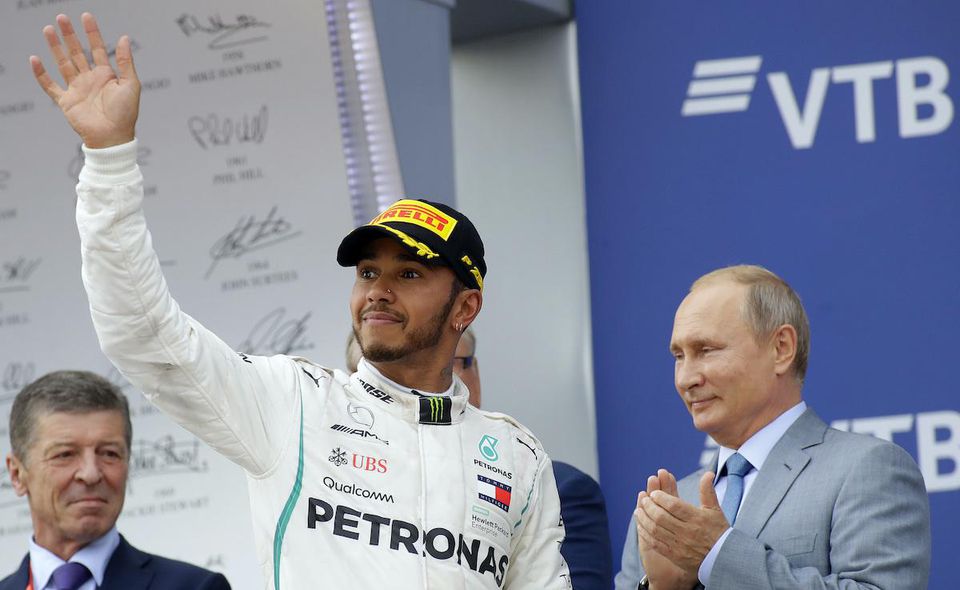 Lewis Hamilton oslavuje na pódiu vedľa prezidenta Vladimira Putina po jeho víťazstve pretekov nedeľňajšej Veľkej ceny Ruska.
