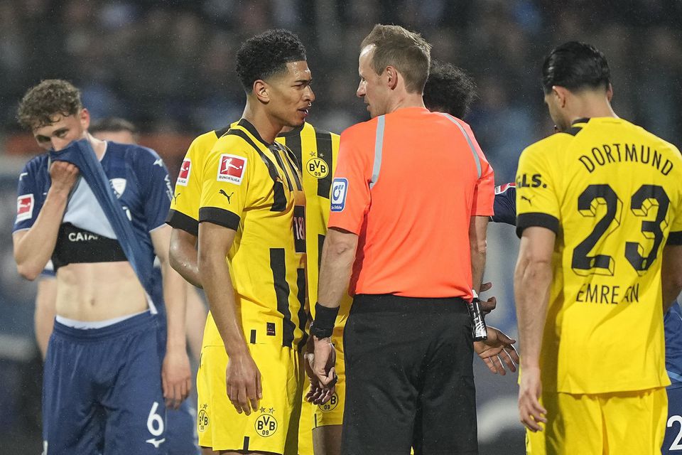 Rozhodca Sascha Stegemann diskutuje s hráčom Dortmundu Jude Bellinghamom.
