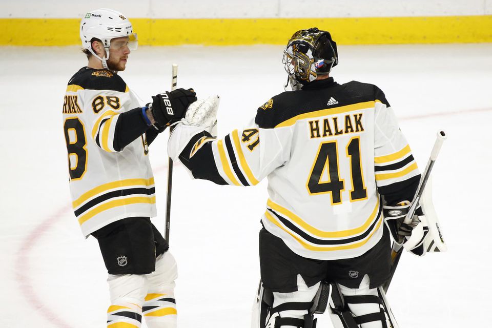 Hráči Bostonu Bruins zľava David Pastrňák a Jaroslav Halák