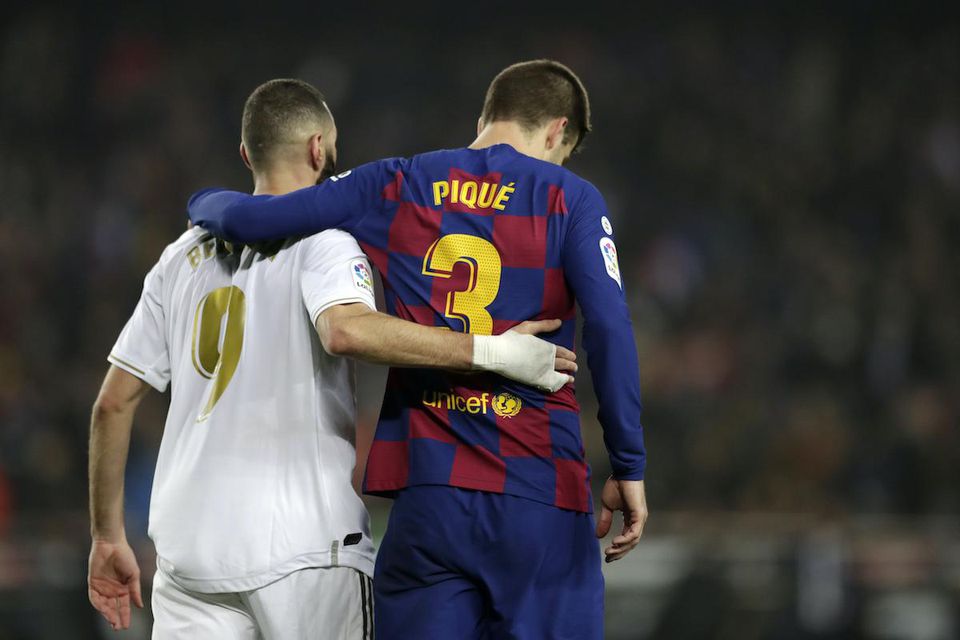 Hráč FC Barcelony Gerard Pique (vpravo) a hráč Realu Madrid Karim Benzema.