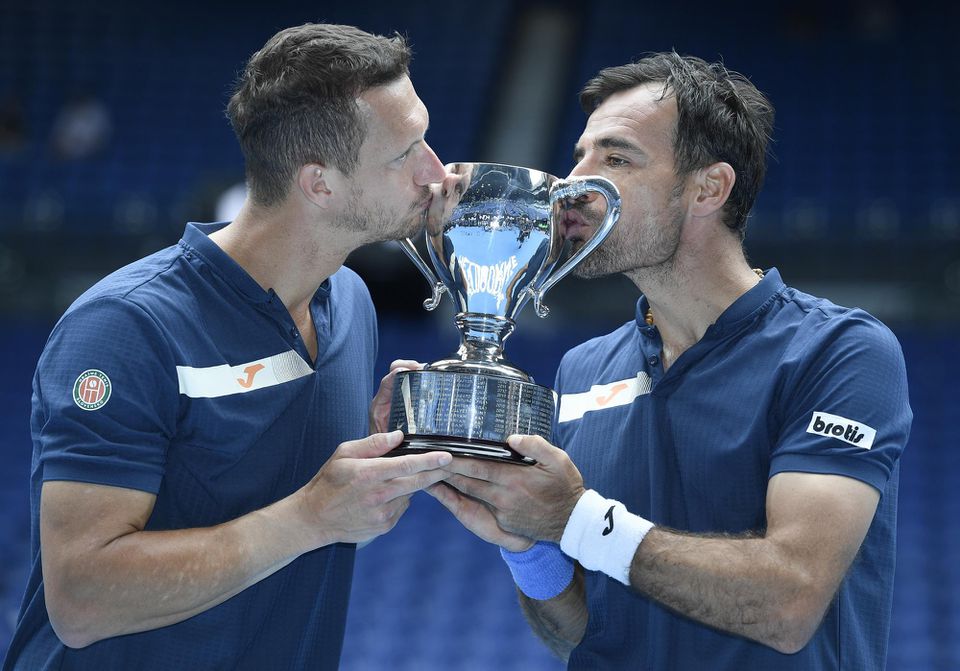 Slovensko-chorvátska dvojica Filip Polášek (vľavo) a Ivan Dodig bozkáva trofej po víťazstve vo finále mužskej štvorhry na Australian Open