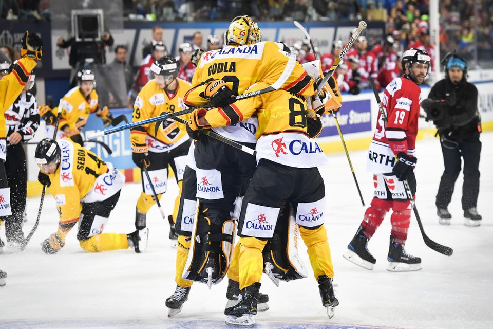 Hokejisti KalPa Kuopio sa radujú s brankárom Denisom Godlom po víťazstve vo finále Spenglerovho pohára