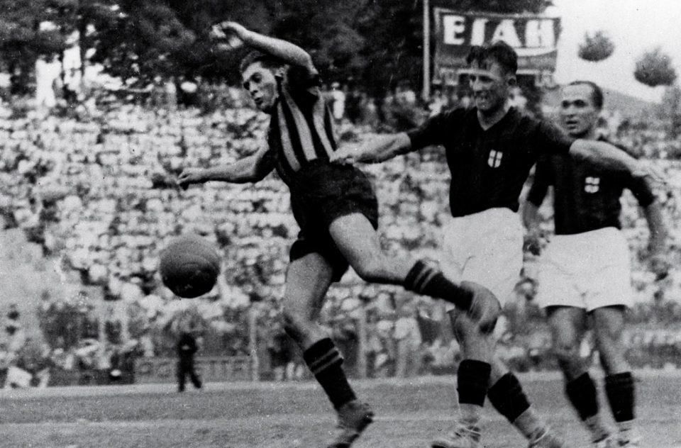 Giuseppe Meazza v drese Interu, bránený dvomi súpermi z AC, pri zakončení.