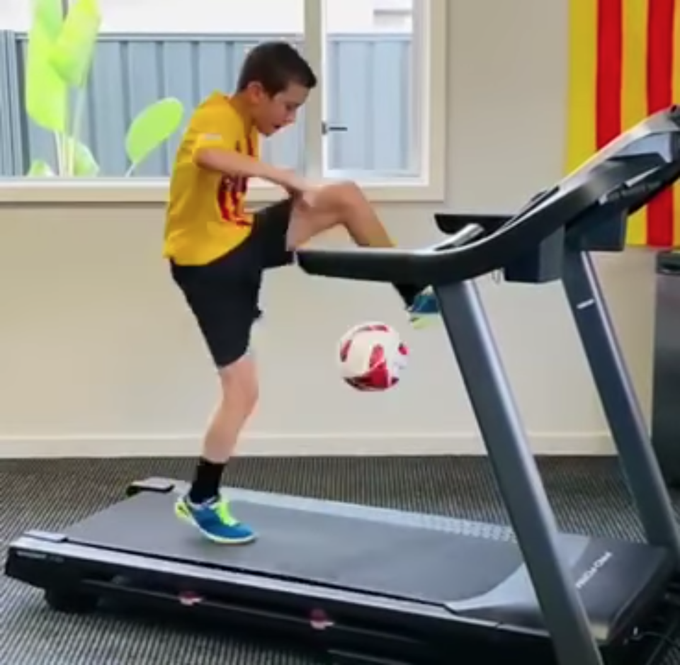 Chlapec v drese FC Barcelona na bežiacom páse.