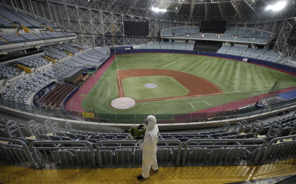 Na snímke zamestnanec v ochrannom odeve dezinfikuje vnútorné priestory na bejzbalovom štadióne Gocheok Sky Dome v juhokórejskom Soule.