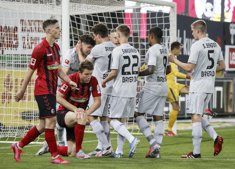Hráč Leverkusenu Kai Havertz (vľavo v pozadí) oslavuje so spoluhráčmi gól.