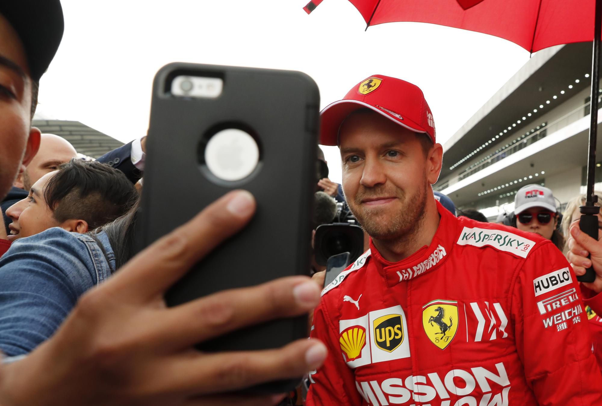 Nemecký pilot Formuly 1 Sebastian Vettel z tímu Ferrari pózuje fanúšikom počas autogramiády.