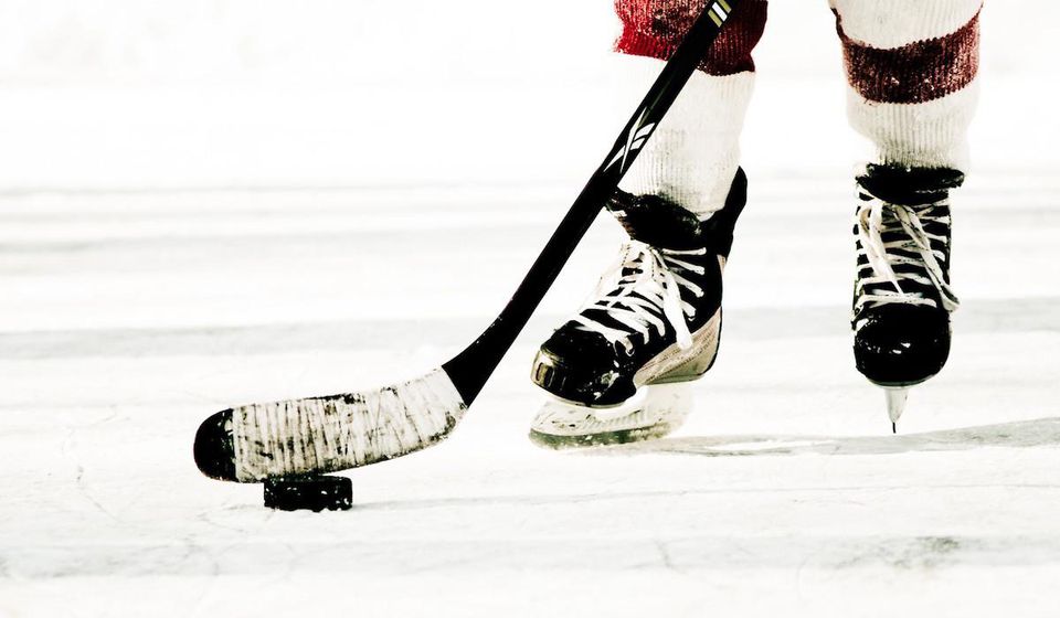 Hokejista na ľade s pukom.