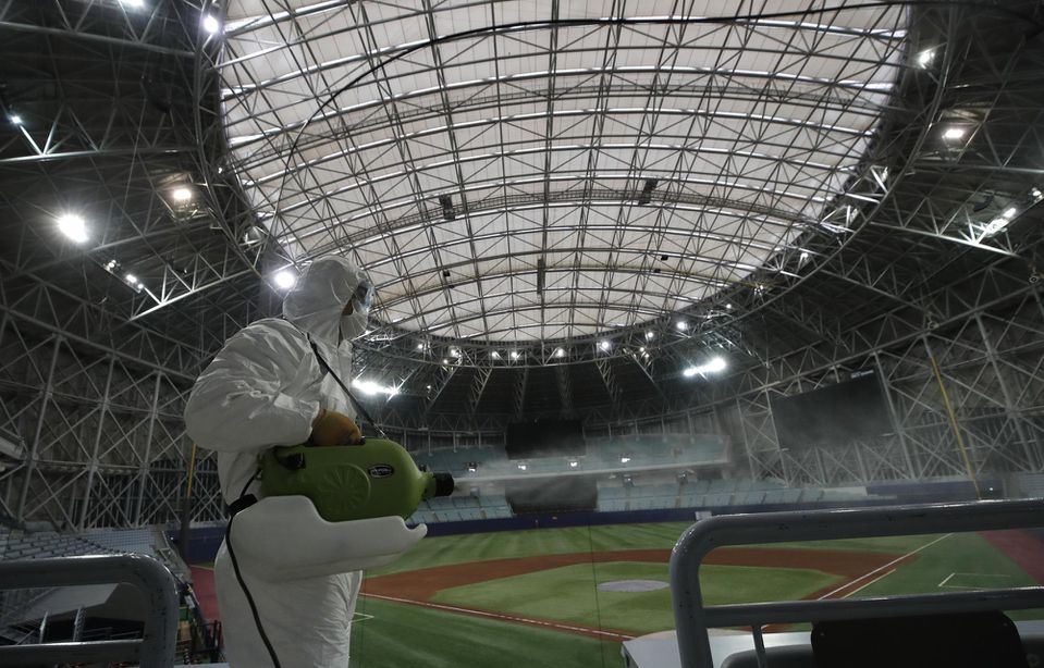 Zamestnanec v ochrannom odeve dezinfikuje vnútorné priestory na bejzbalovom štadióne Gocheok Sky Dome v juhokórejskom Soule.
