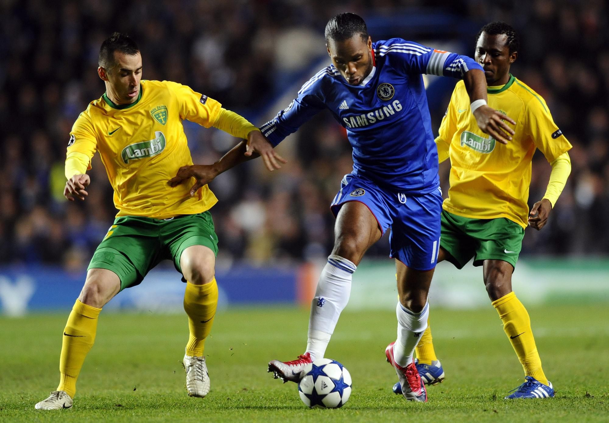 Ľubomír Guldan, vpravo Babatounde Bello (obaja Žilina) a uprostred Didier Drogba (Chelsea)