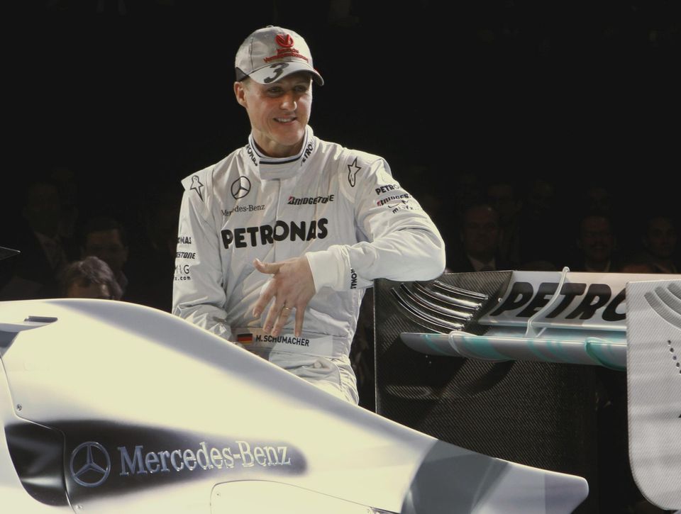 Nemecký jazdec F1 Michael Schumacher pózuje pri automobile.