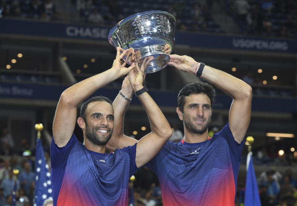 Kolumbijskí tenisti Juan Sebastian Cabal (vľavo) a Robert Farah držia na hlavou trofej po triumfe vo finále mužskej štvorhry na US Open v New Yorku.