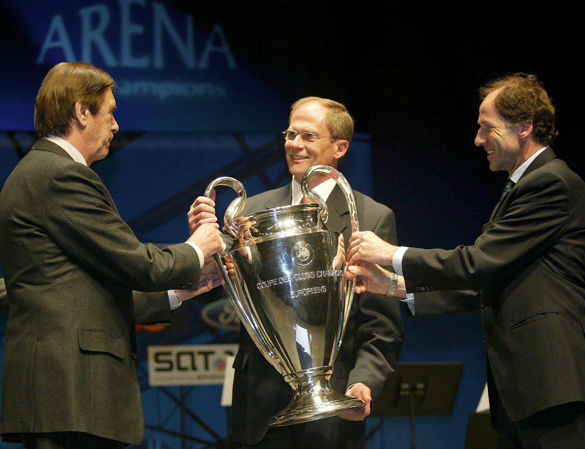 Bývalí talianski futbalisti, hráči tímu AC Miláno Cesare Maldini (vľavo) a Franco Baresi (vpravo), vracajú trofej Ligy majstrov UEFA šéfovi exekutívy UEFA Larsovi-Christenovi Olssonovi (uprostred) počas ceremoniálu odovzádvania pohára 15. apríla 2004 v nemeckom Gelsenkirchene.