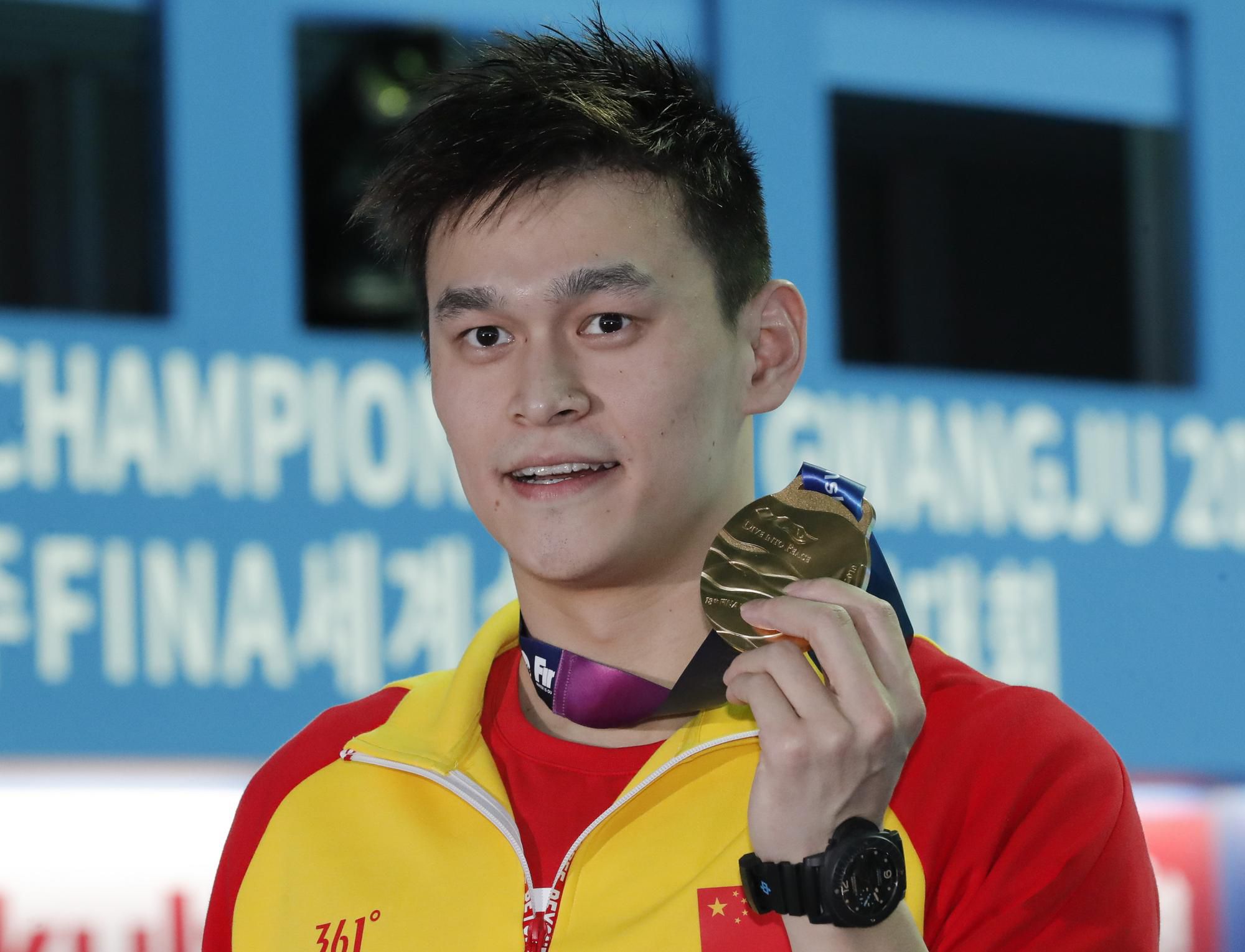 Čínsky plavec Jang Sun pózuje so zlatou medailou.