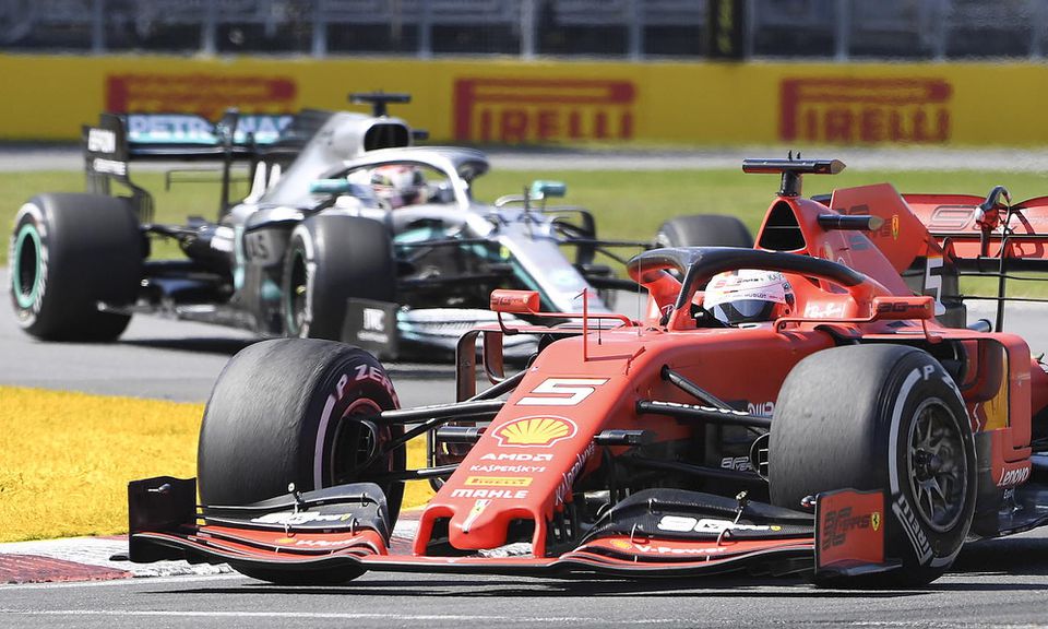 Jazdec Ferrari Sebastian Vettel a v jeho tesnom závese Lewis Hamilton na Mercedese.