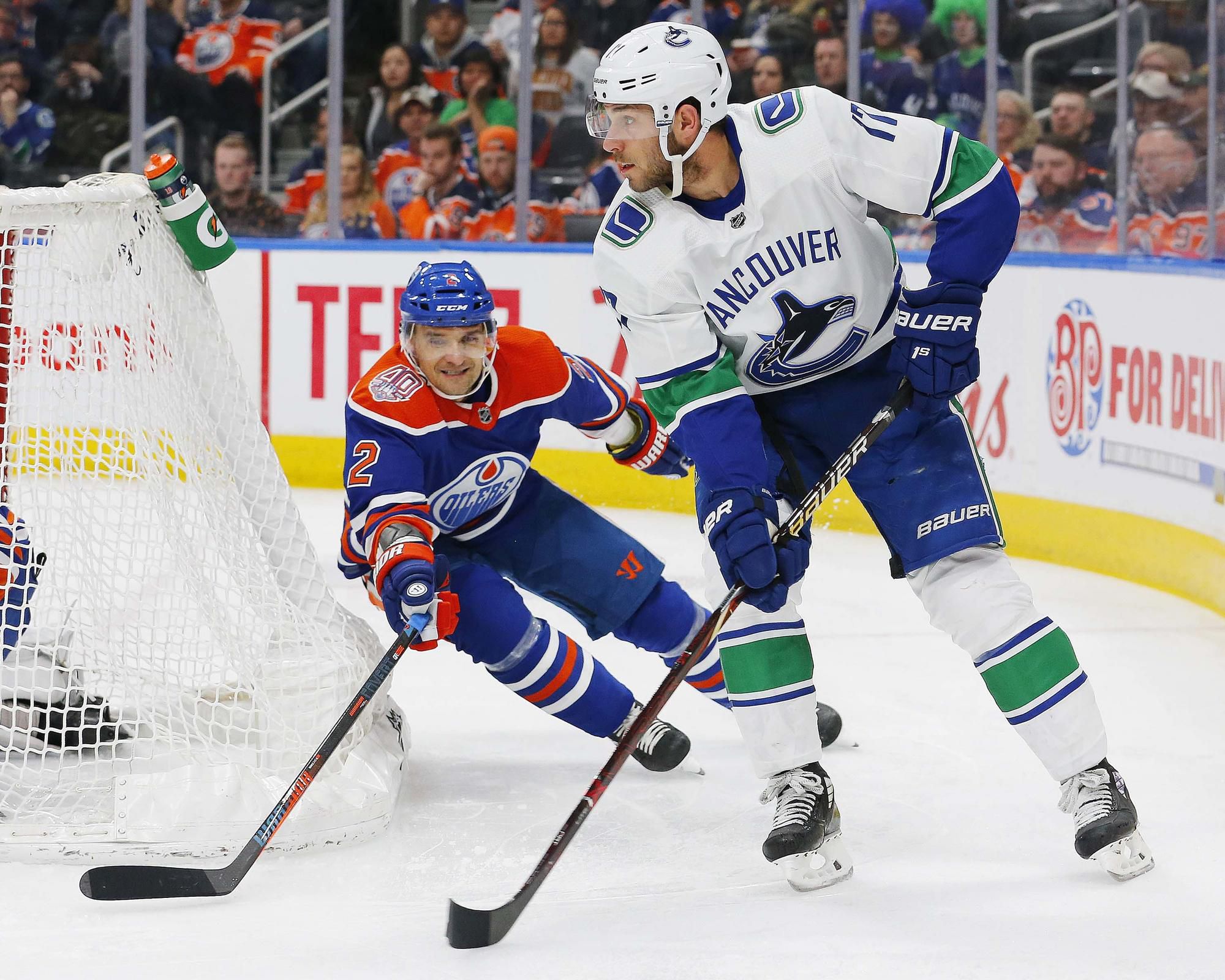 Andrej Sekera v súboji s hráčom Vancouveru Canucks.