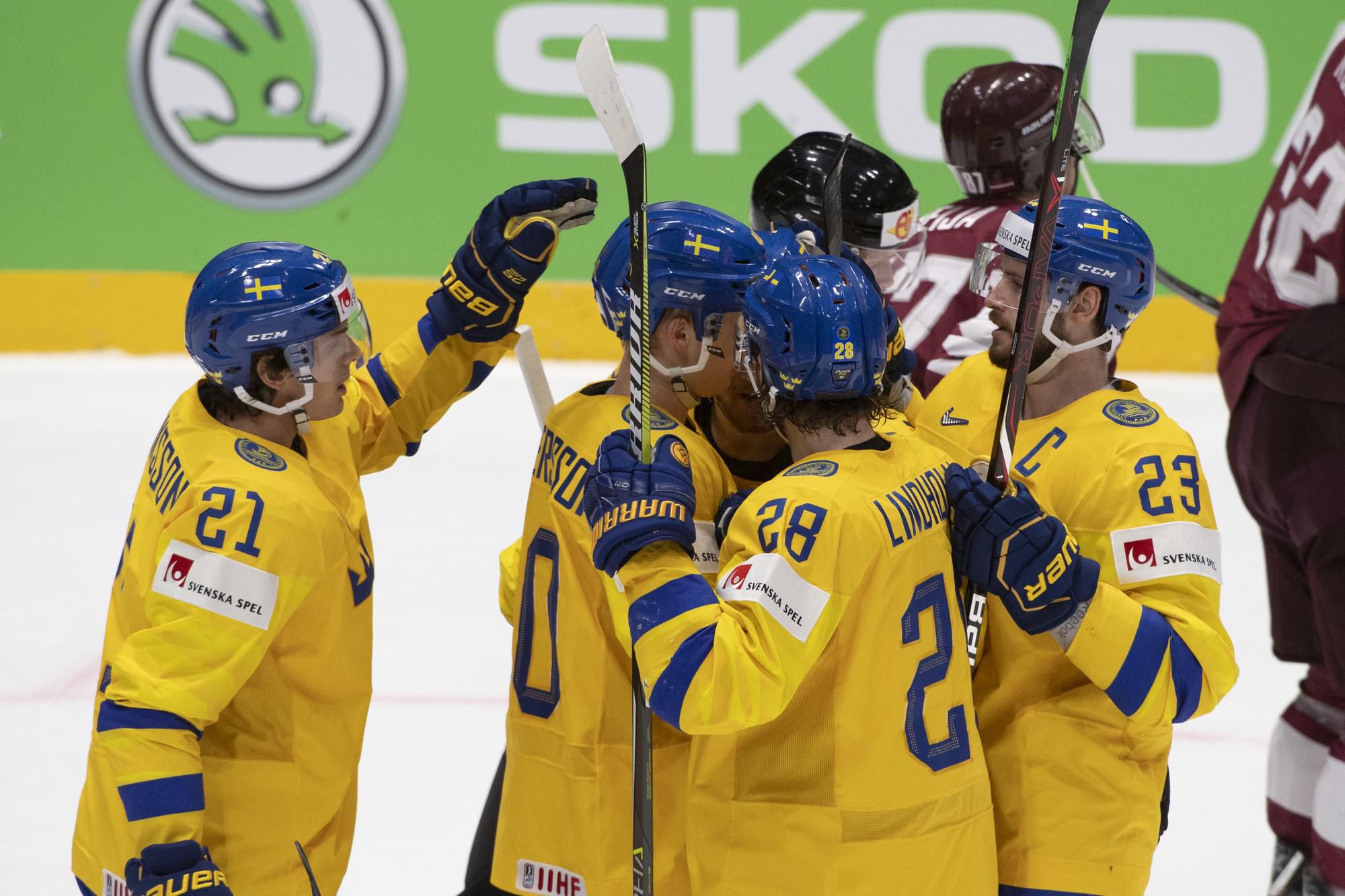 Hokejisti Švédska oslavujú gól do siete Lotyšska