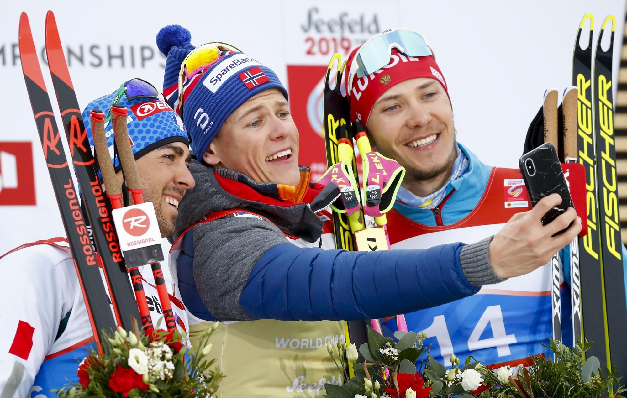 Nórsky bežec na lyžiach Johannes Hösflot Kläbo (uprostred) sa fotí po triumfe v šprinte voľnou technikou na majstrovstvách sveta.