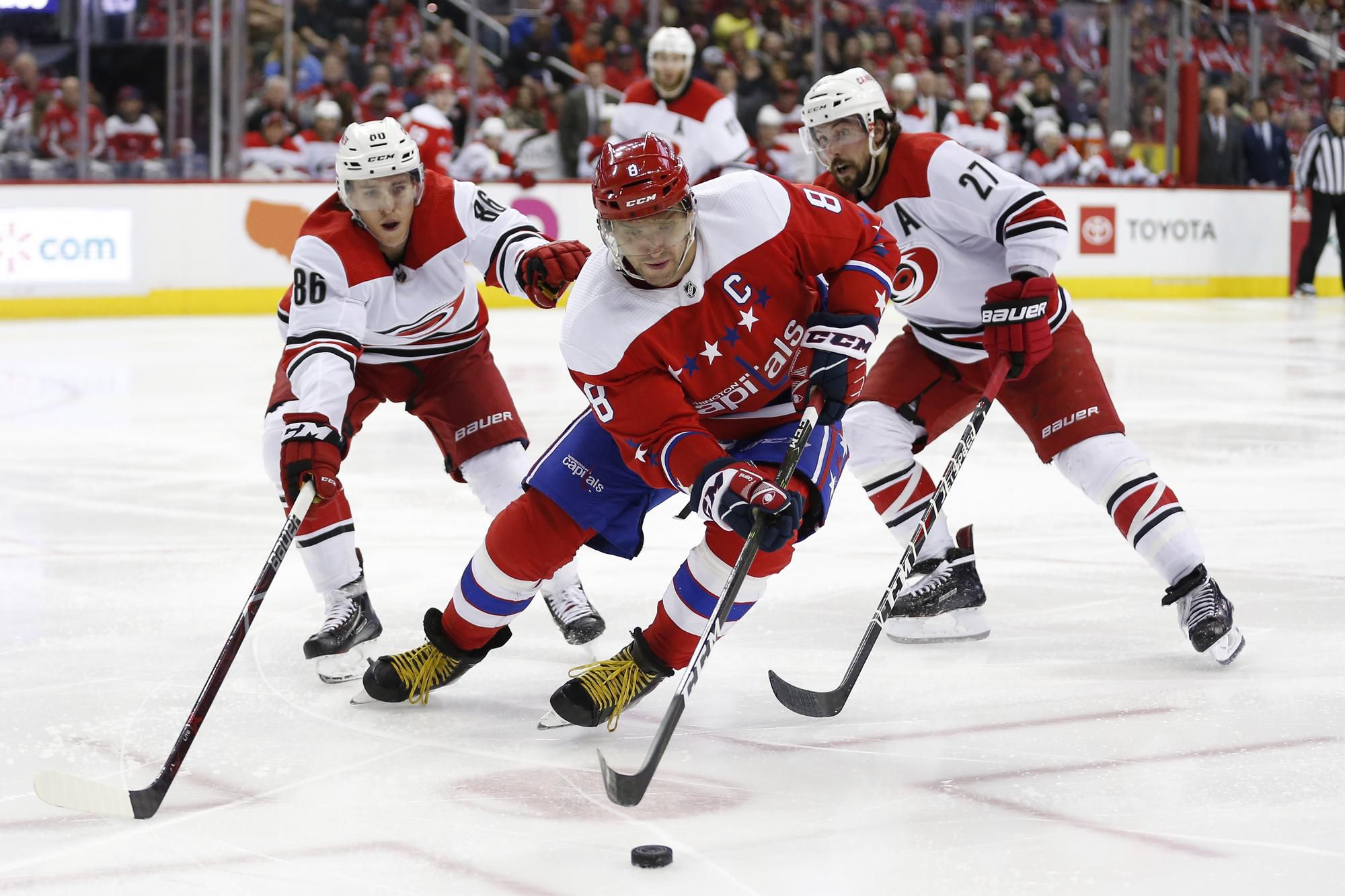 Ruský útočník Alexander Ovečkin (Washington Capitals) v súboji s hráčmi Caroliny.