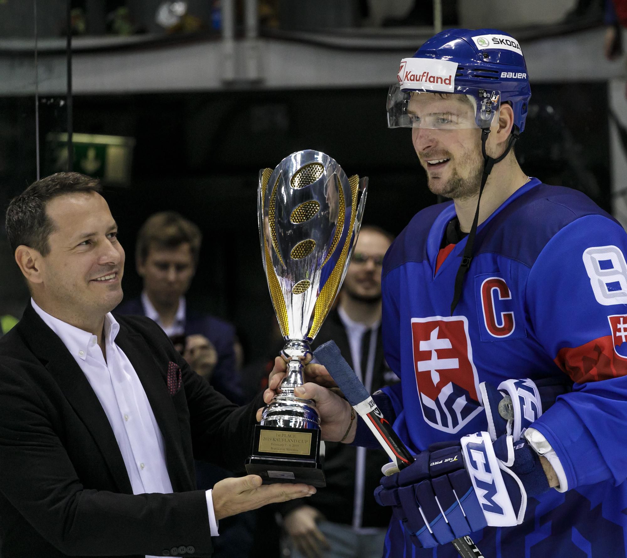 Prezident SZĽH Martin Kohút odovzdáva pohár kapitánovi slovenského tímu Michalovi Sersenovi  po víťazstve nad Olympijským tímom Ruska v zápase hokejového turnaja Kaufland Cup.