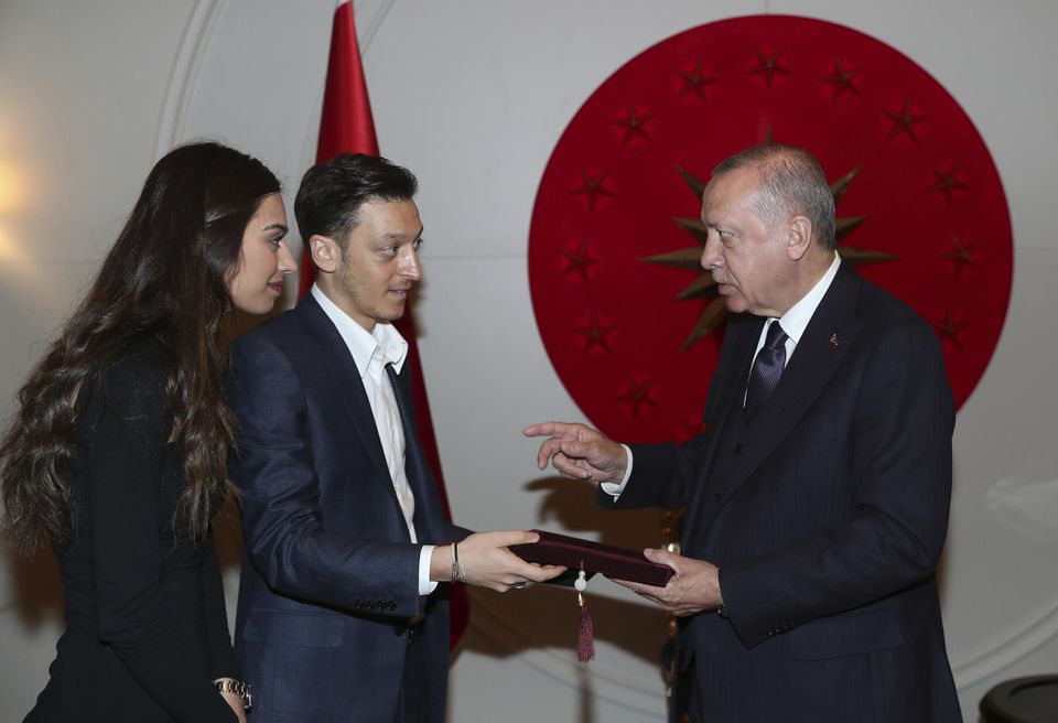 Turecký prezident Recep Tayyip Erdogan (vpravo) dostáva pozvánku na svadbu od nemeckého futbalistu tureckého pôvodu Mesuta Özila (uprostred) a jeho snúbenice Amine Gulseovej v Istanbule