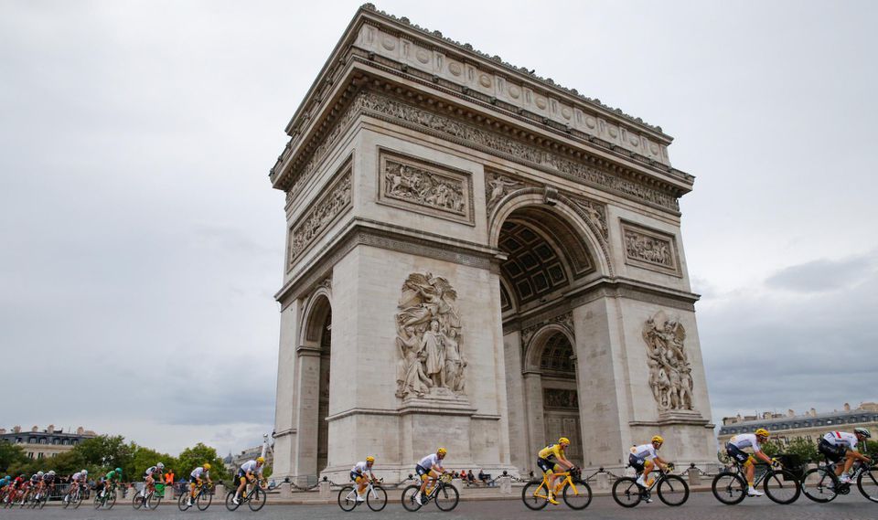 Pelotón s Chrisom Froomom v žltom drese prechádza okolo Víťazného oblúka na Champs Elysées (Tour de France 2017)