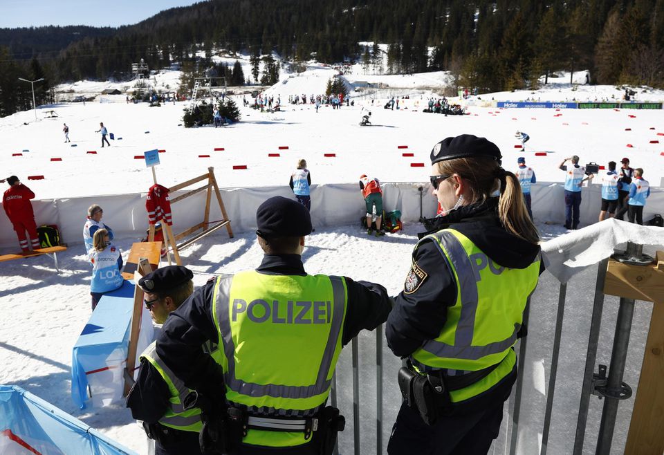 Rakúski policajti stoja v cieli pretekov mužov v behu na lyžiach