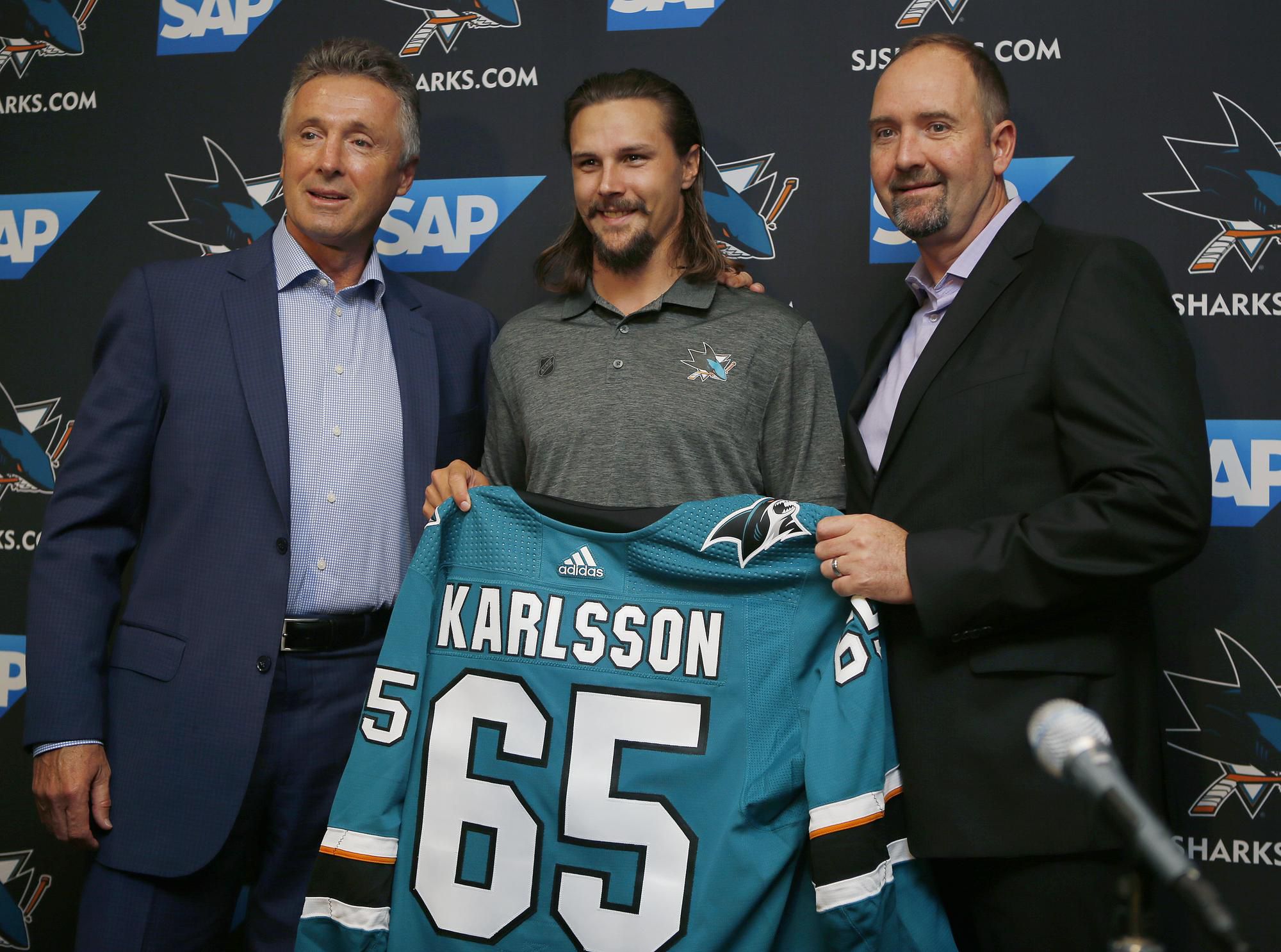 Erik Karlsson spolu s generálnym manažérom Dougom Wilsonom a trénerom Peterom DeBoerom.