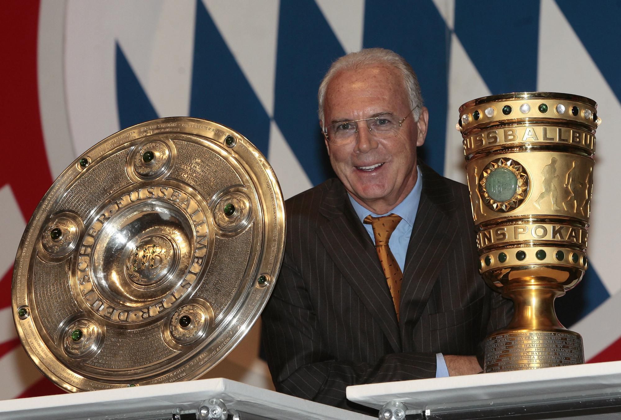 Franz Beckenbauer pózuje s trofejou pre víťaza Bundesligy a DFB Pokal.