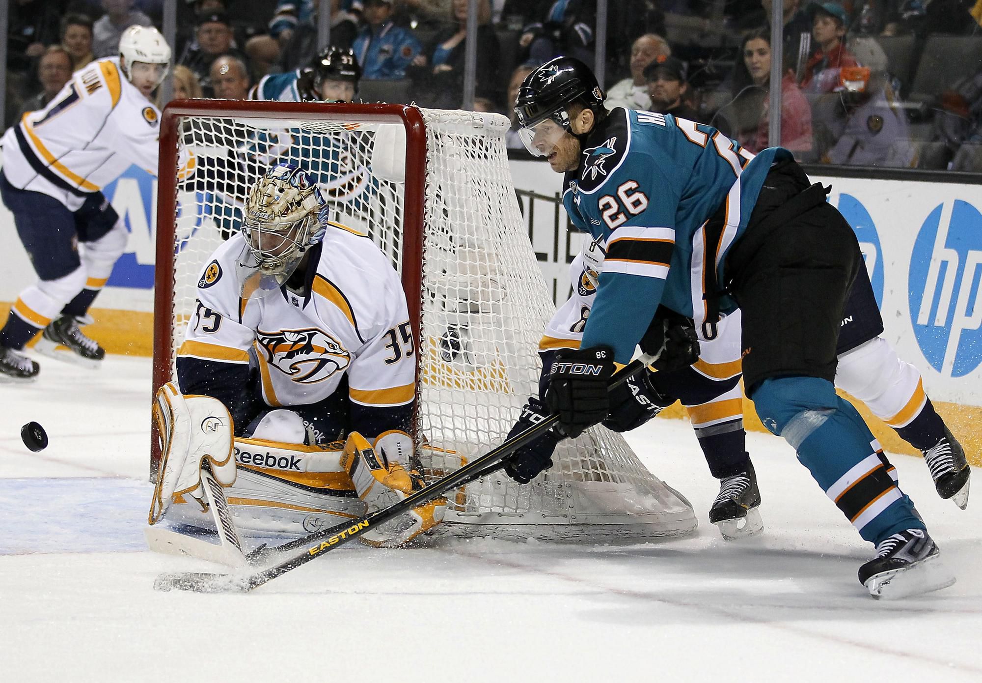 Brankár Nashville Predators Pekka Rinne (35) blokuje Slováka Michala Handzuša (vpravo) zo San Jose Sharks.