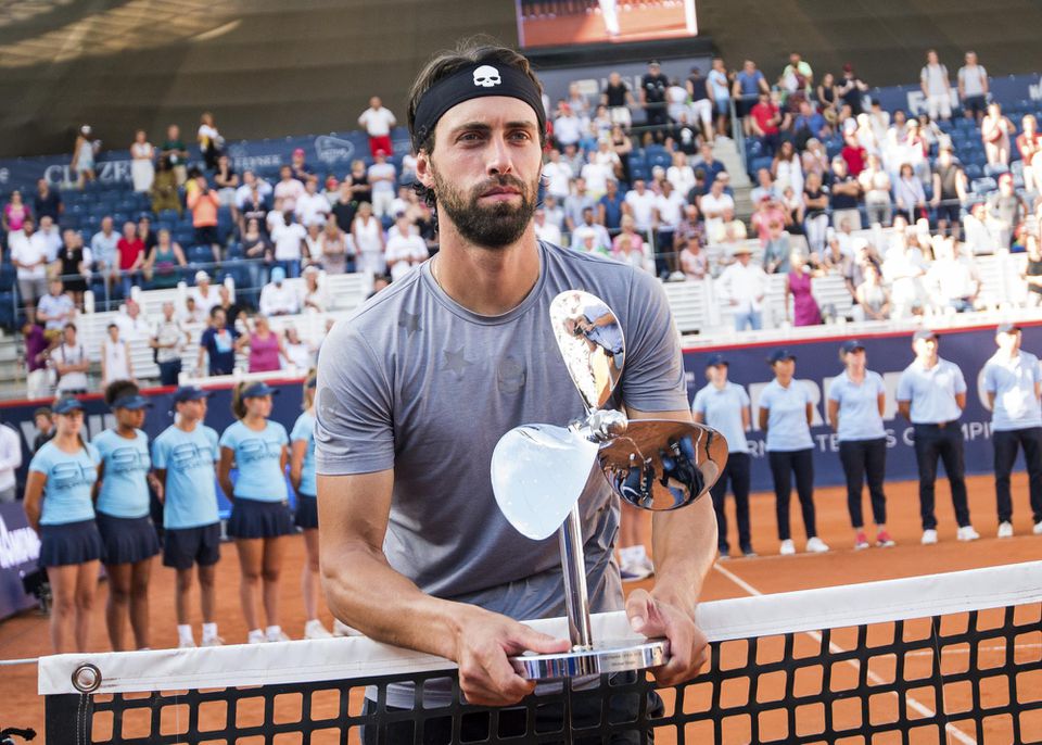 Gruzínsky tenista Nikolos Bassilašvili pózuje s trofejou po zisku premiérového titulu v kariére na okruhu ATP.