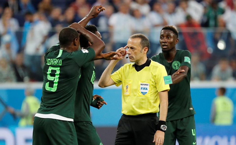 Hráči Nigérie diskutujú s tureckým rozhodcom Cüneytom Cakirom