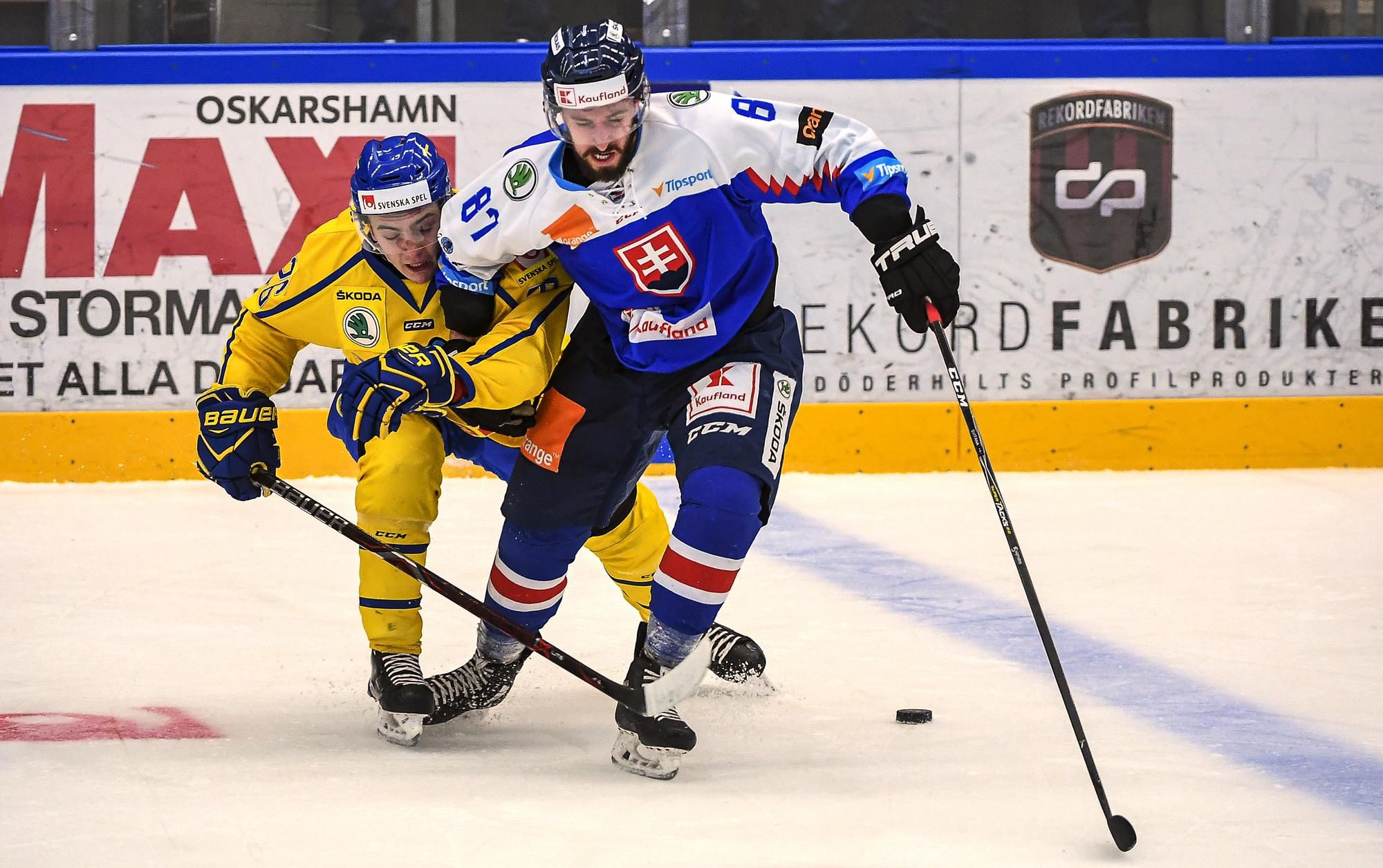 Slovenský hokejista Patrik Svitana (vpravo) a Švéd Erik Brännström bojujú o puk.
