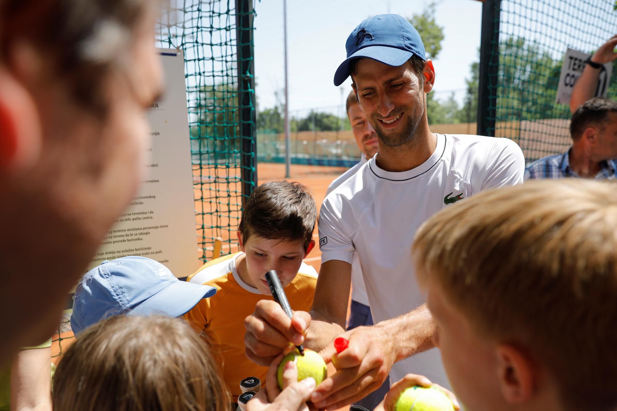 Novak Djokovič rozdáva podpisy fanúšikom.