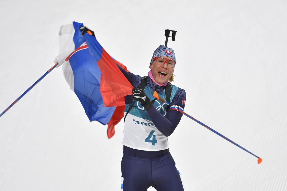 Slovenská biatlonistka Anastasia Kuzminová drží slovenskú vlajku v cieli po zisku zlatej olympijskej medaily počas pretekov žien s hromadným štartom na 12,5 km.