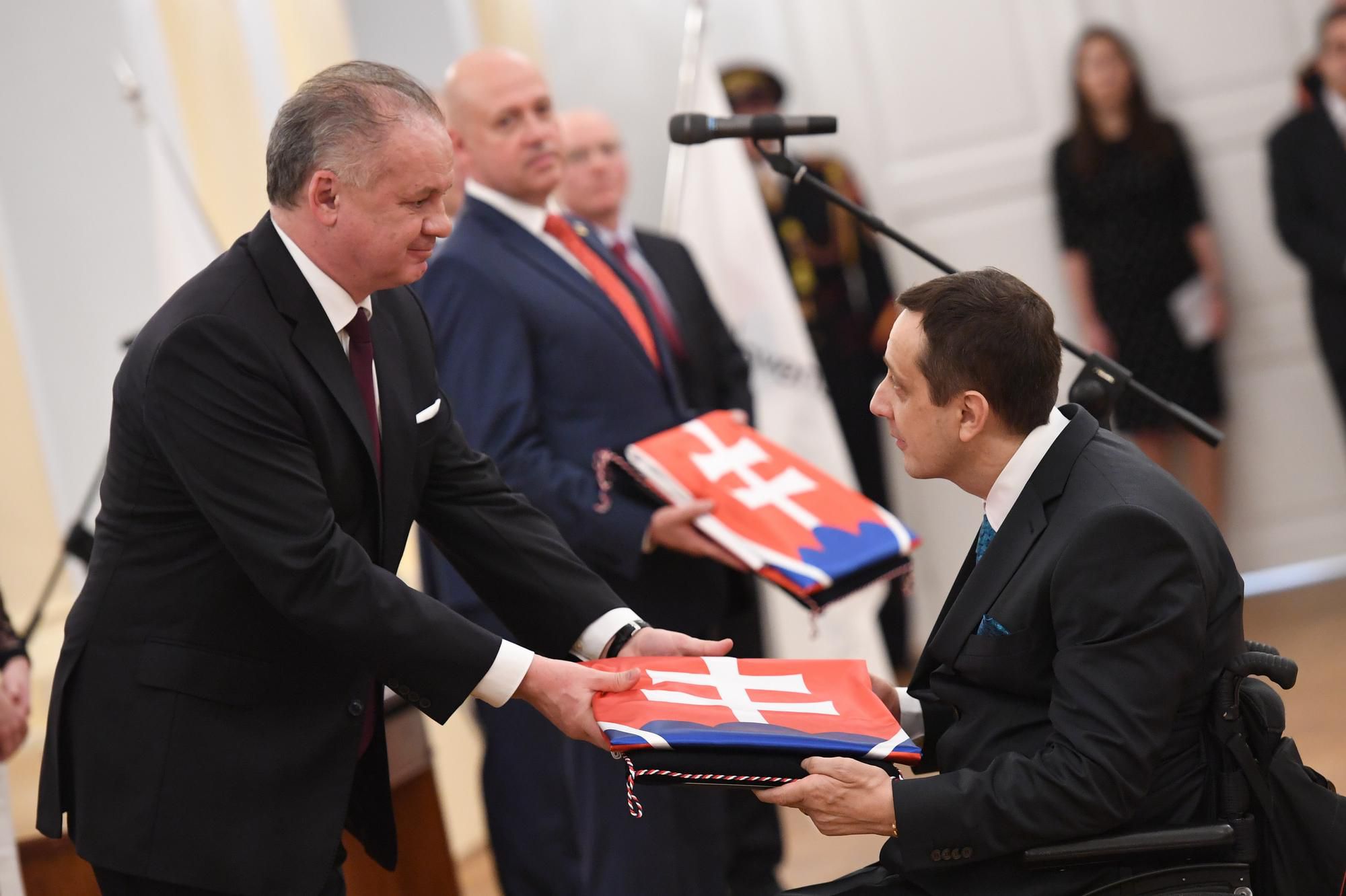 Predseda Slovenského paralympijského výboru (SPV) Ján Riapoš si preberá dekrét a slovenskú vlajku z rúk prezidenta SR Andreja Kisku.
