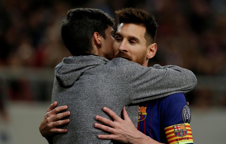 Lionel Messi v objatí fanúšika na ihrisku