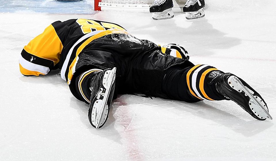 Sidney Crosby leží zranený na ľade.