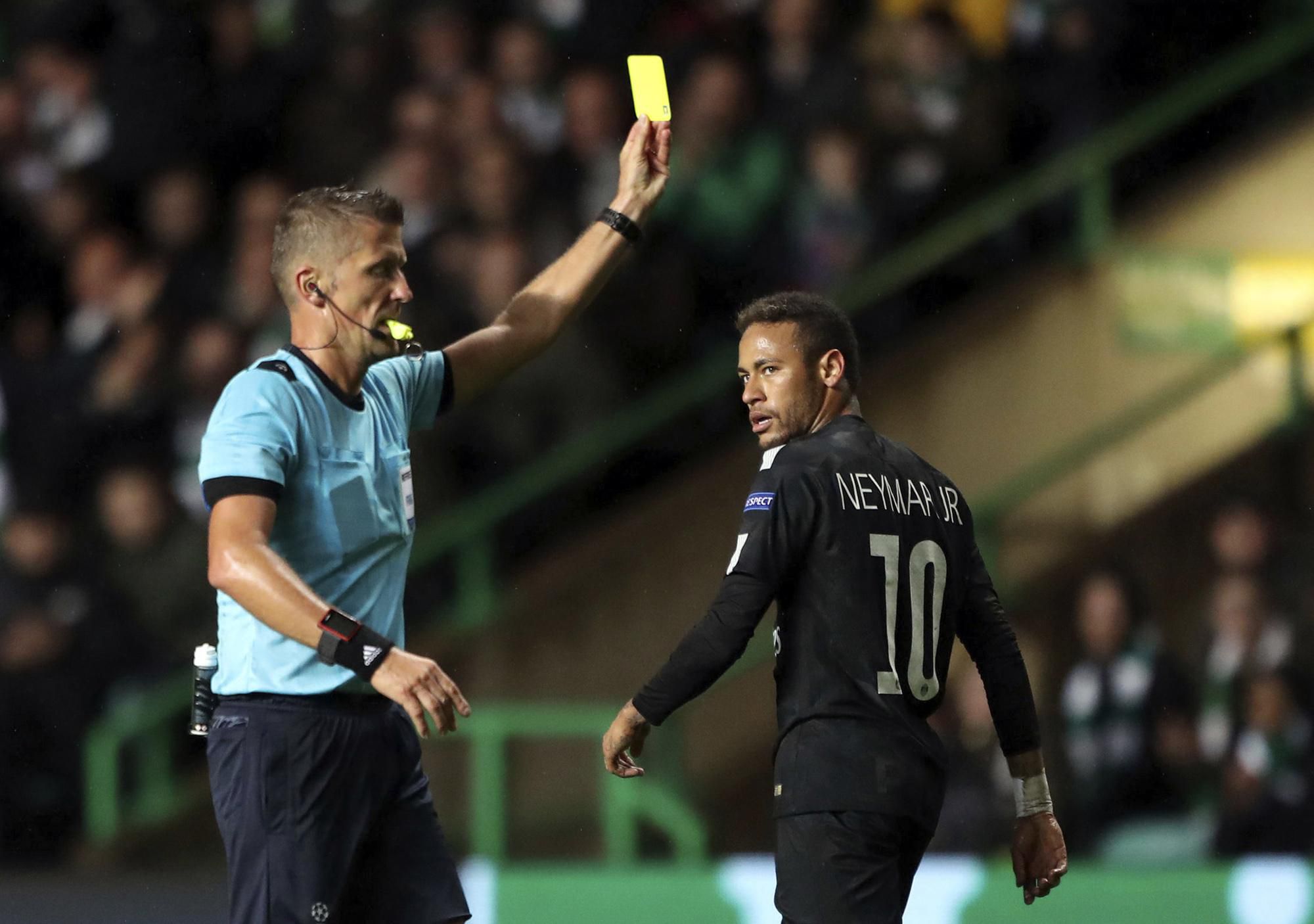 Neymar dostáva žltú kartu v zápase B-skupiny Ligy majstrov vo futbale Celtic Glasgow - Paríž St. Germain.