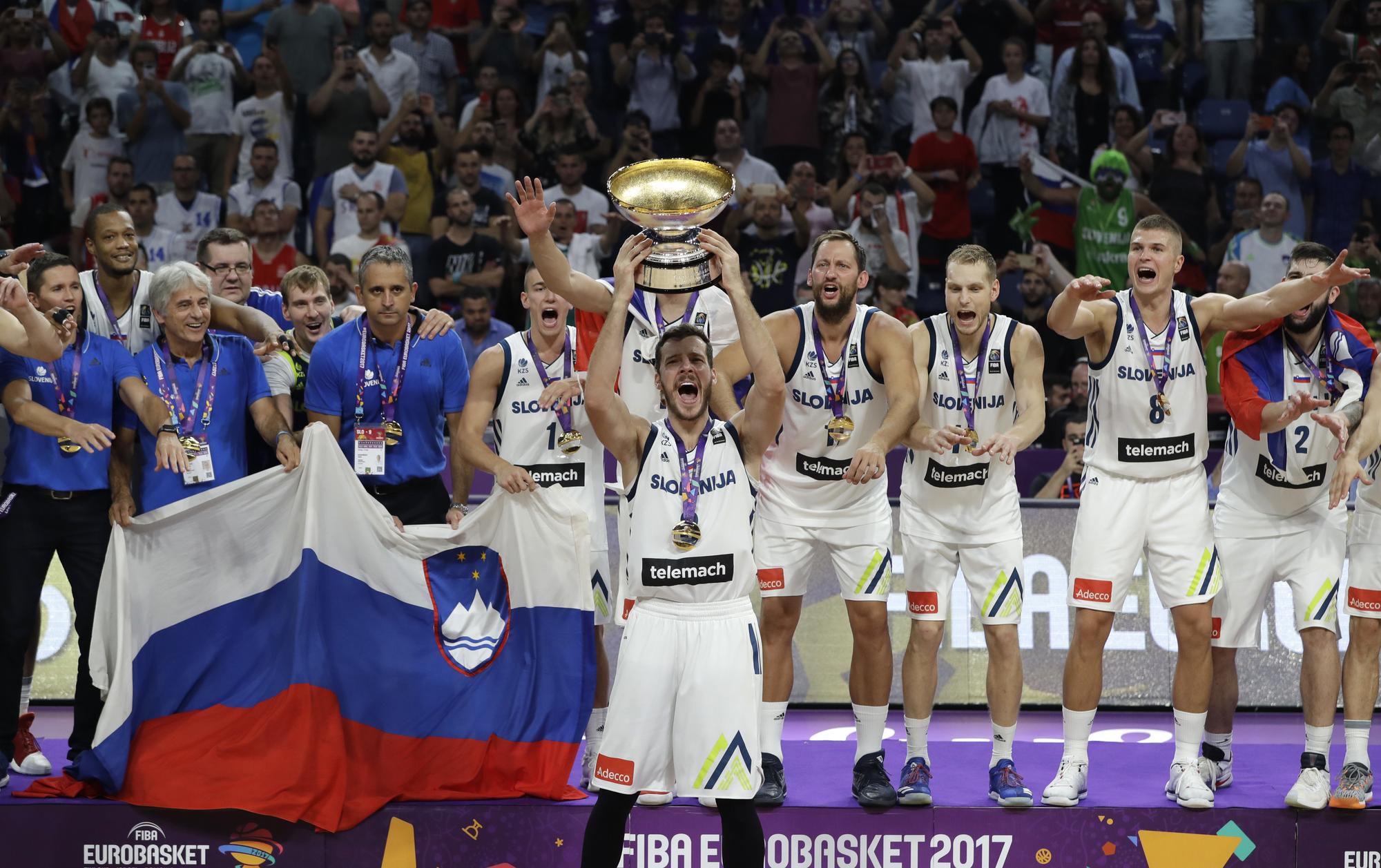 Slovinský basketbalový tím oslavuje s trofejou európskeho šampióna.