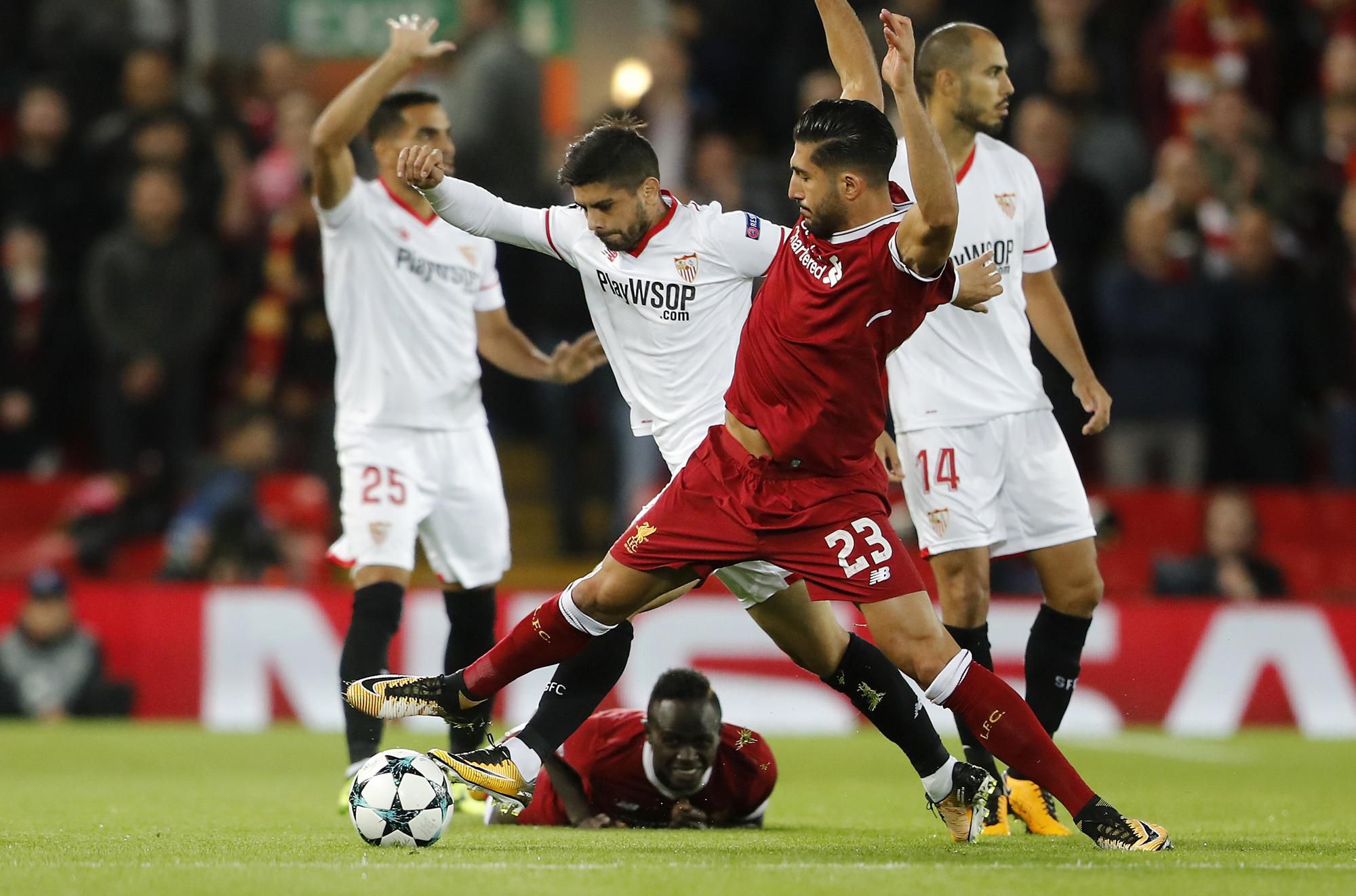Emre Can (vpravo) a hráč Sevilly Ever Banega v súboji o loptu v zápase E-skupiny Ligy majstrov  vo futbale FC Liverpool – FC Sevilla.