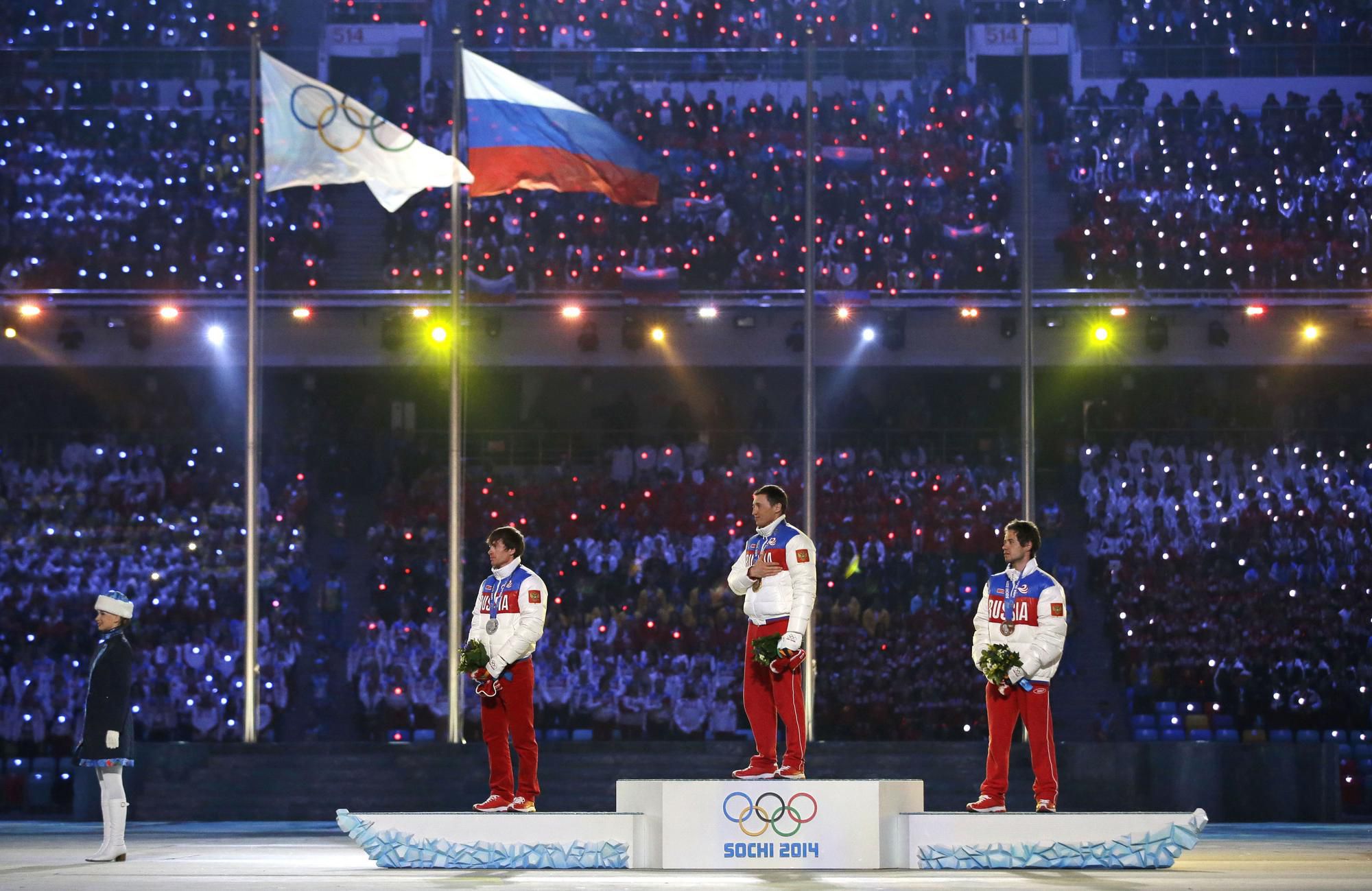 Maxim Vylegžanin, víťaz Alexander Legkov a bronzový Iľja Černousov pózujú s medailami z kráľovskej disciplíny v behu na lyžiach na 50 km voľnou technikou.
