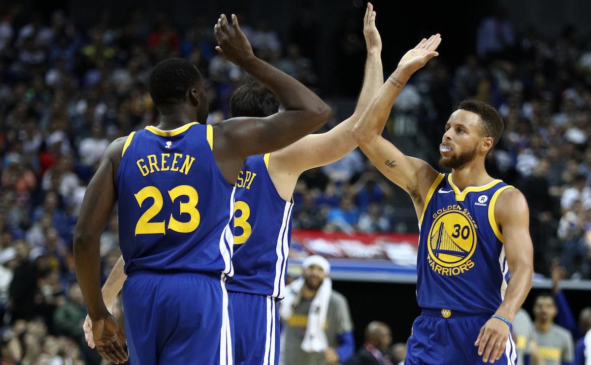 Stephen Curry a high-five so spoluhráčmi (Golden State).