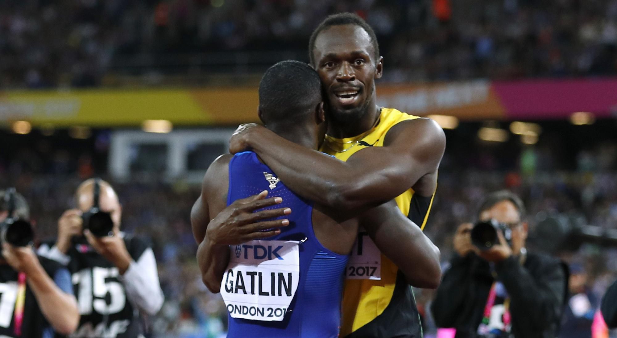 Usain Bolt po svojom poslednom šprinte v kariére objíma víťaza Justina Gatlina